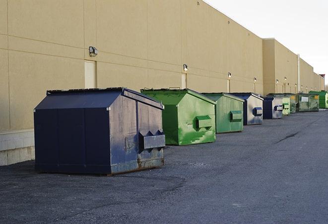 a row of construction dumpsters parked on a jobsite in Goffstown